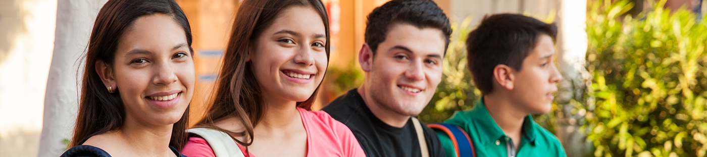 Four teenagers smiling after orthodontics