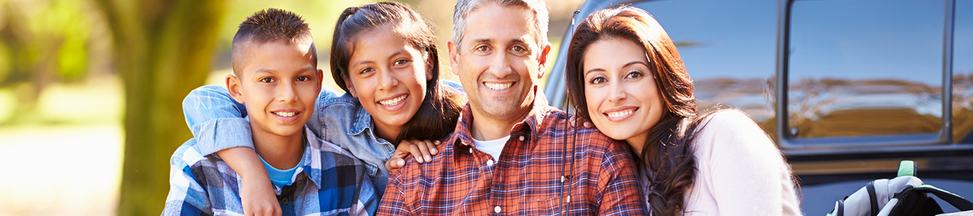Family of four smiling outdoors